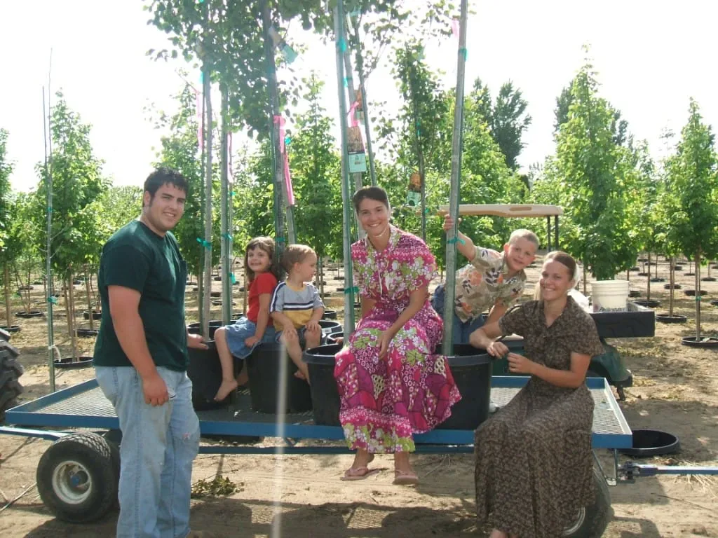 Crew working behind a tractor-mounted planter in an open field