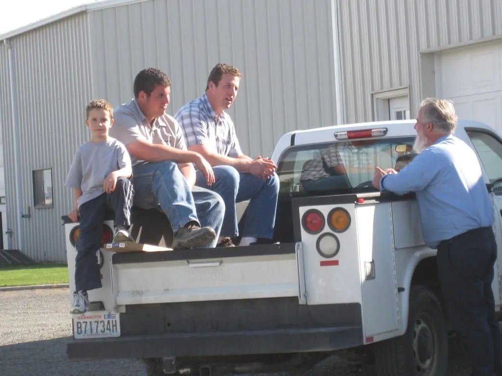 Family and friends gathered at the back of a white utility truck