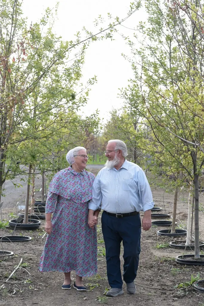 Everett and Sandra walking hand in hand through the nursery rows